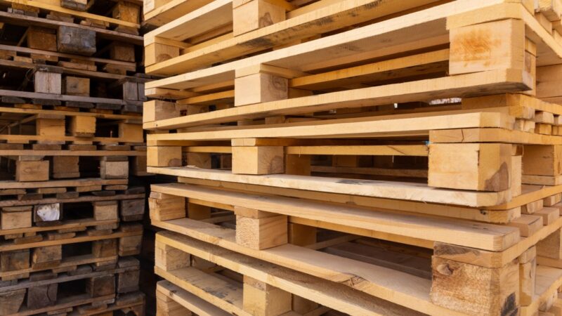 Palets de madera natural apilados, embalaje de transporte afectado por el Reglamento europeo de envases PPWR